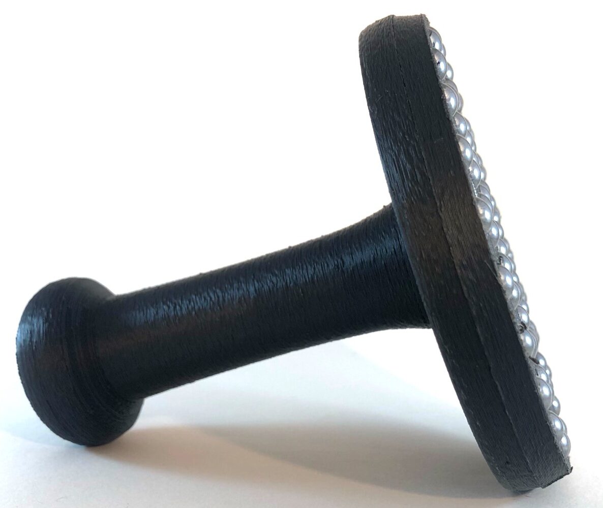 Tall handled black ball bearing baren lying on its side